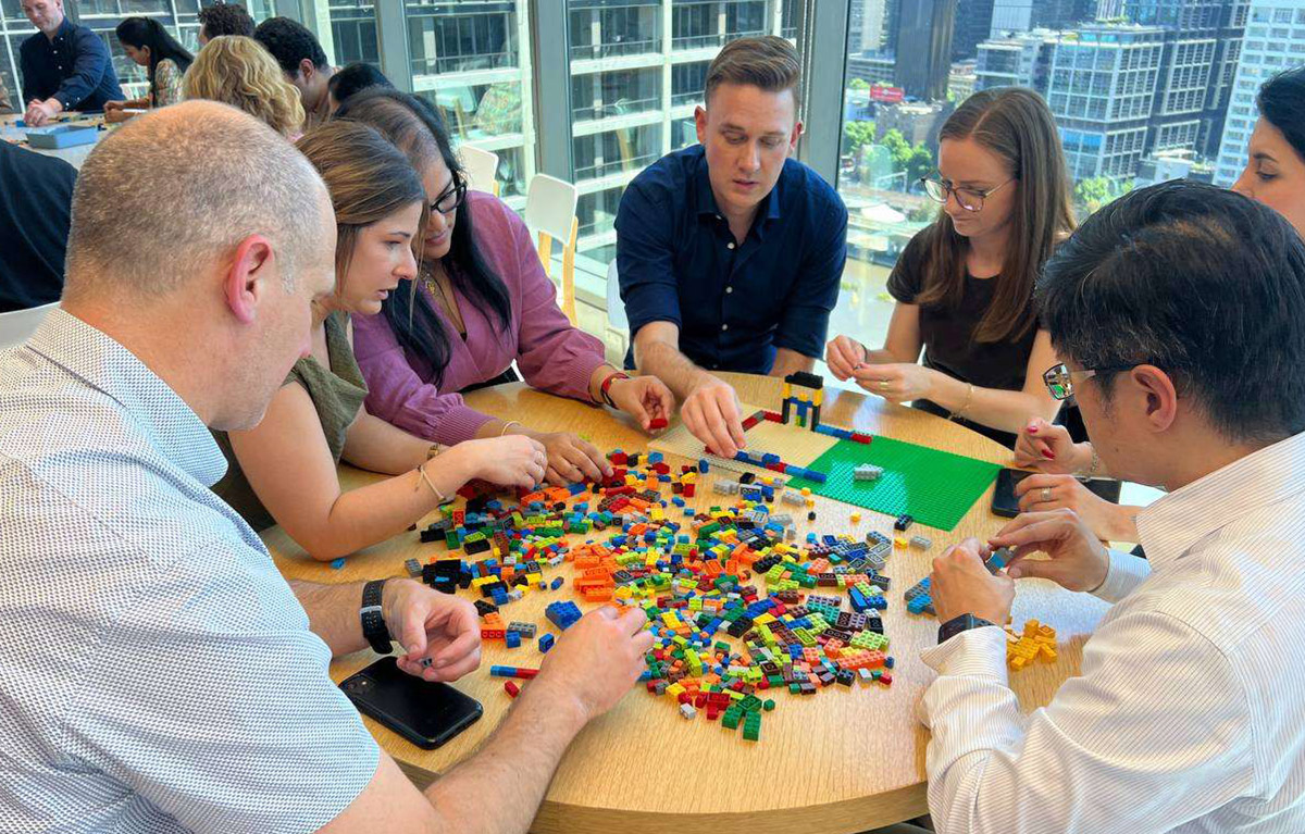 Corporate team building activity with teams competing in LEGO building challenges