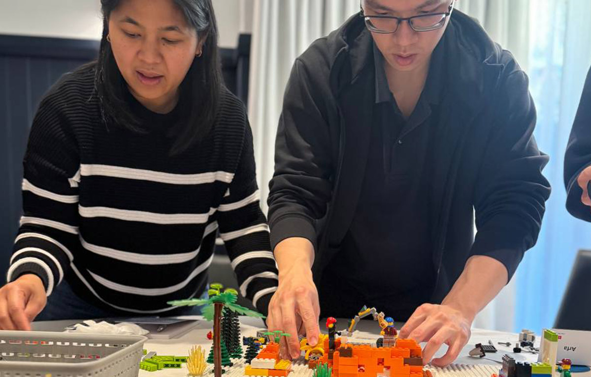 Corporate team building activity with teams competing in LEGO building challenges