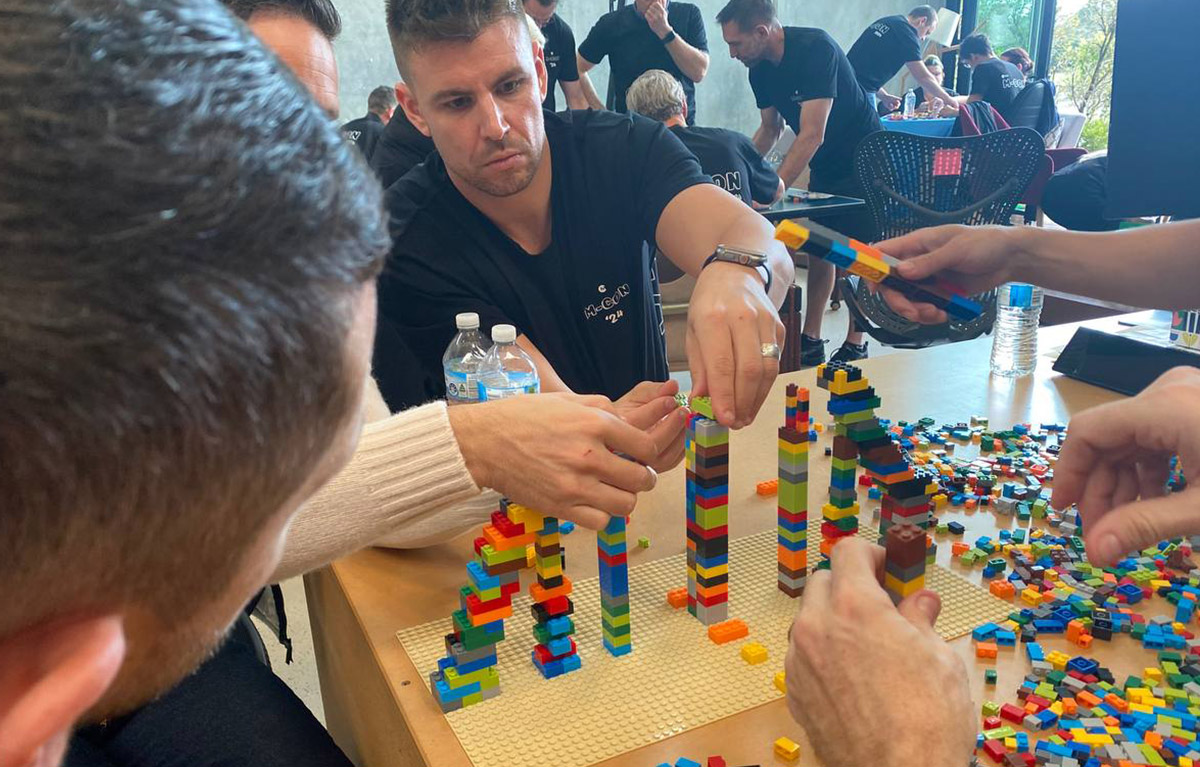 Corporate team building activity with teams competing in LEGO building challenges