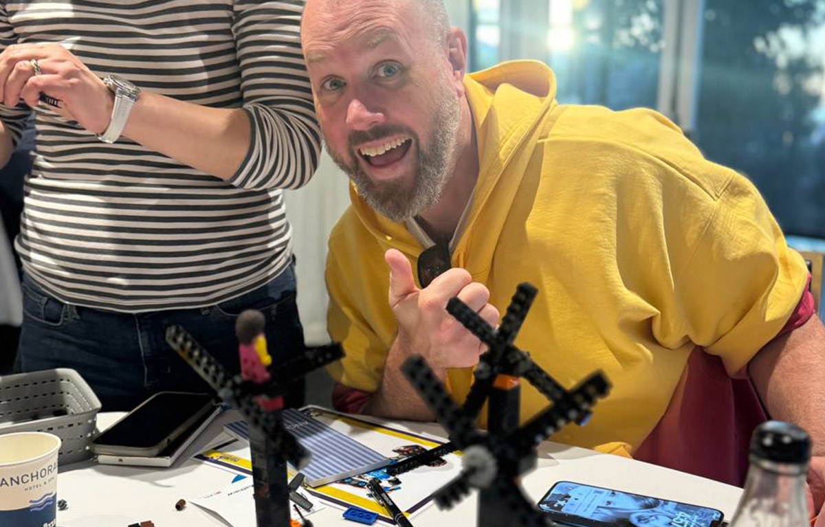 Corporate team building activity with teams competing in LEGO building challenges