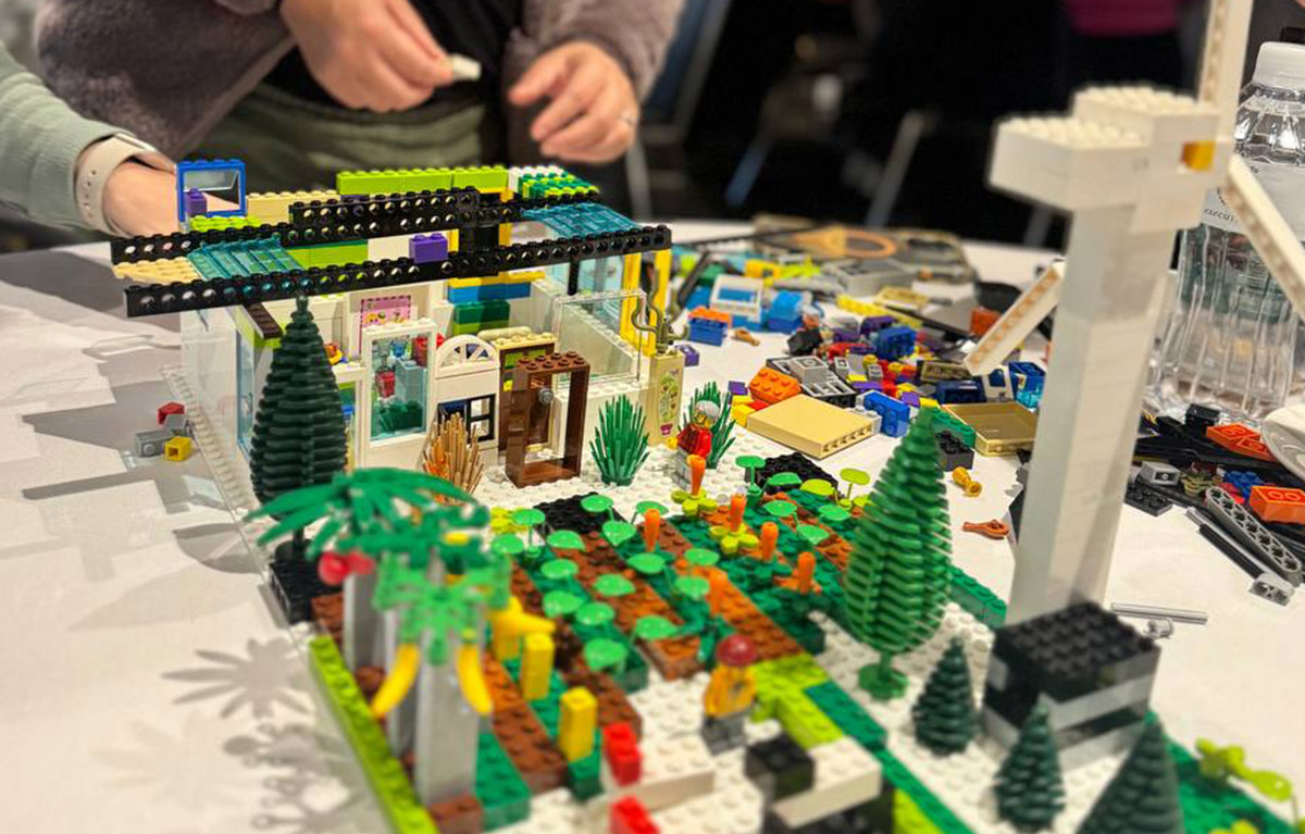 Corporate team building activity with teams competing in LEGO building challenges