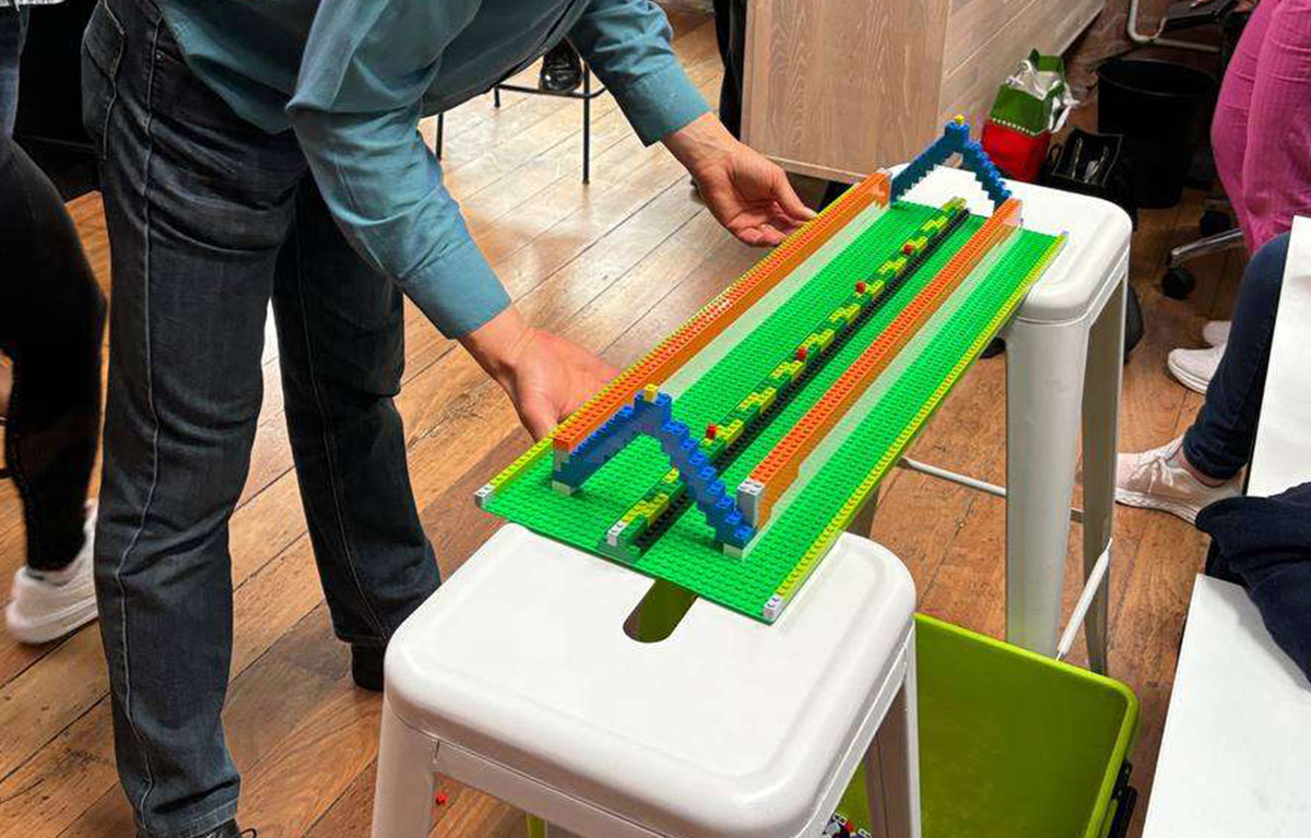 Corporate team building activity with teams competing in LEGO building challenges