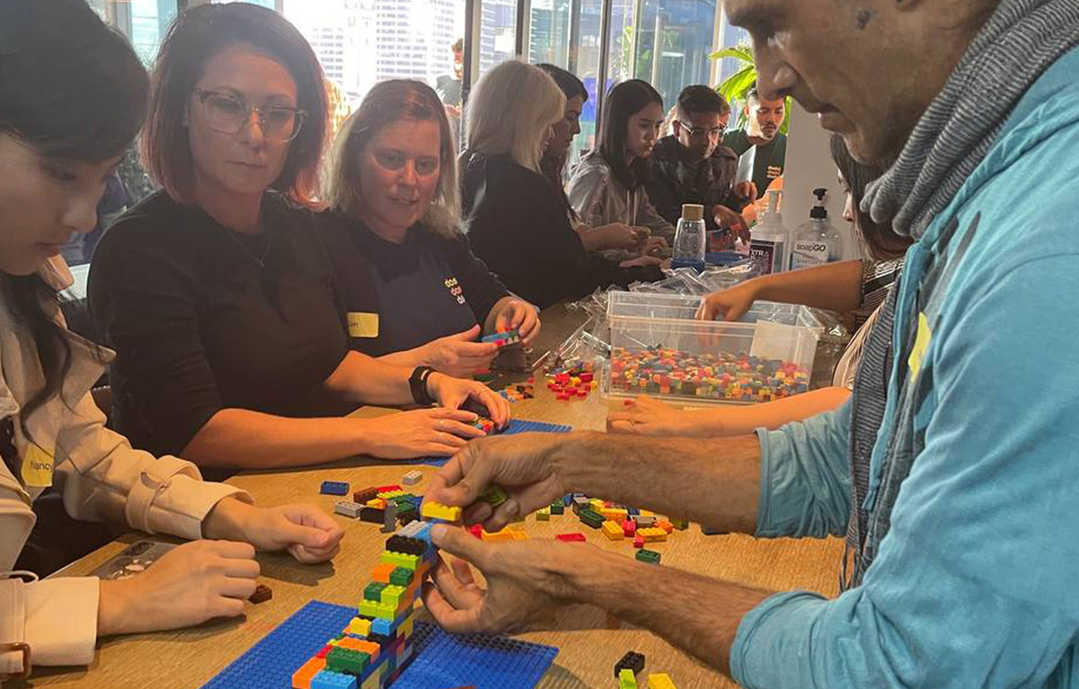 Corporate team building activity with teams competing in LEGO building challenges