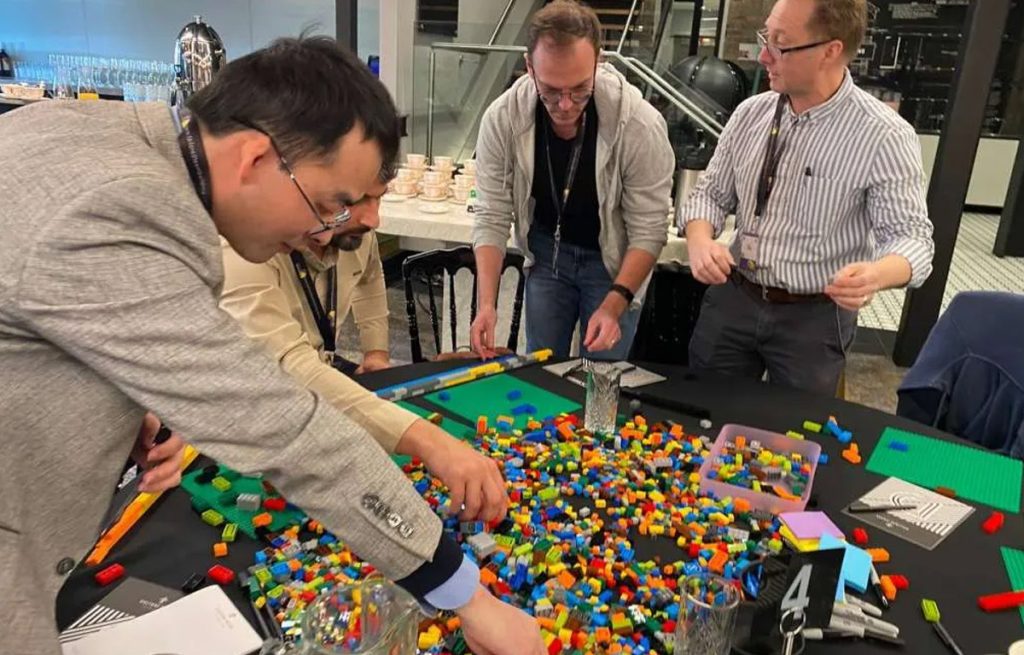 Corporate team celebrating their LEGO masterpiece during a Brick Masters activity