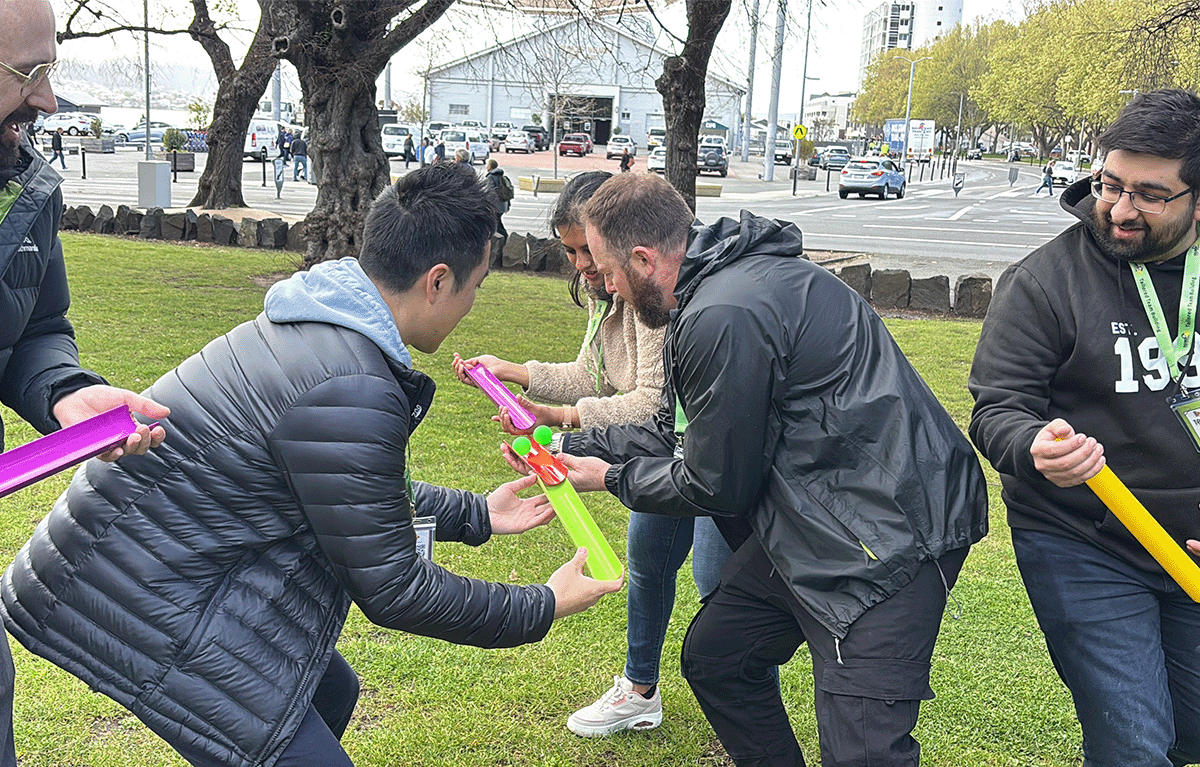 Fun group activities Hobart – colleagues laughing during a creative outdoor team building challenge