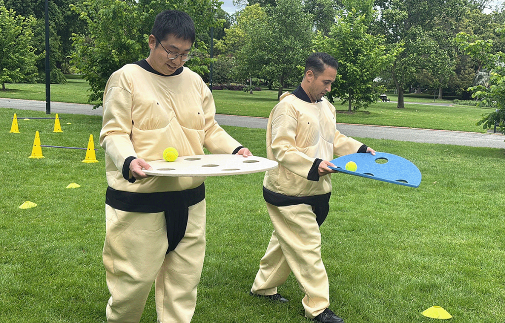 Teams dressed in sumo suits during a large group corporate olympics in Melbourne