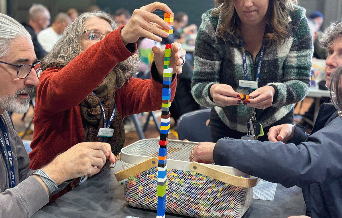 Staff competing in the tallest tower challenge at a Canberra Brick Masters team building event.