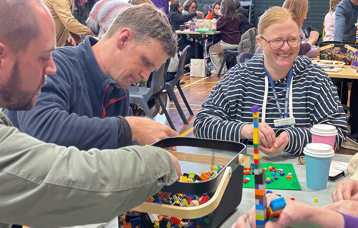 Teams building creative LEGO® masterpieces during an indoor team bonding event in Canberra.