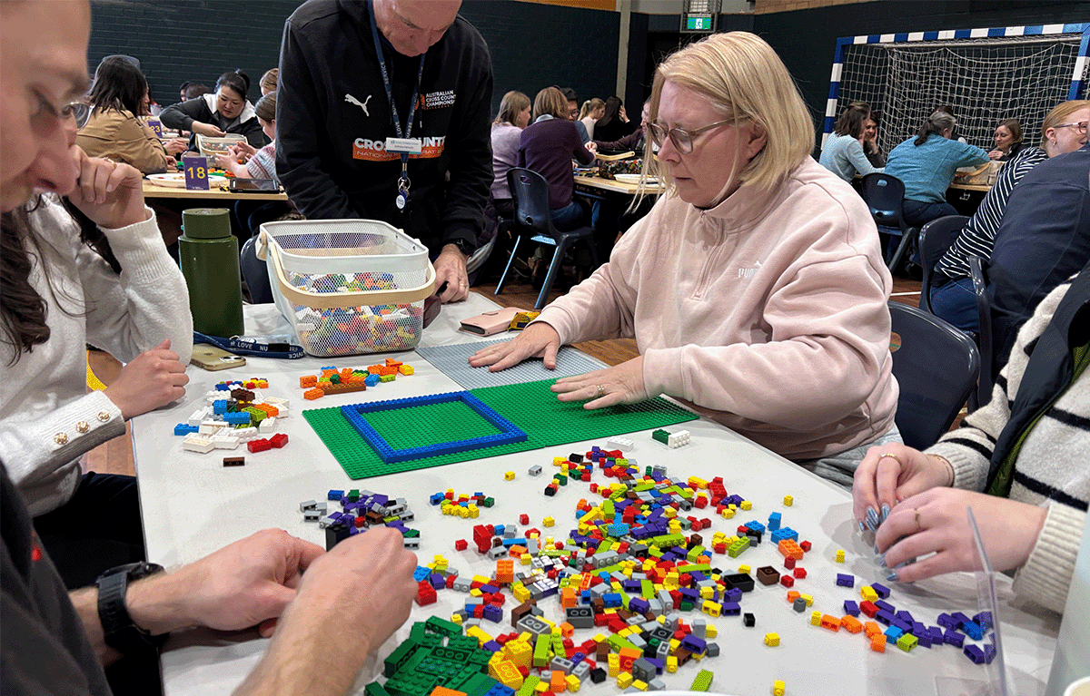 Teams building creative LEGO® masterpieces during an indoor team bonding event in Canberra.