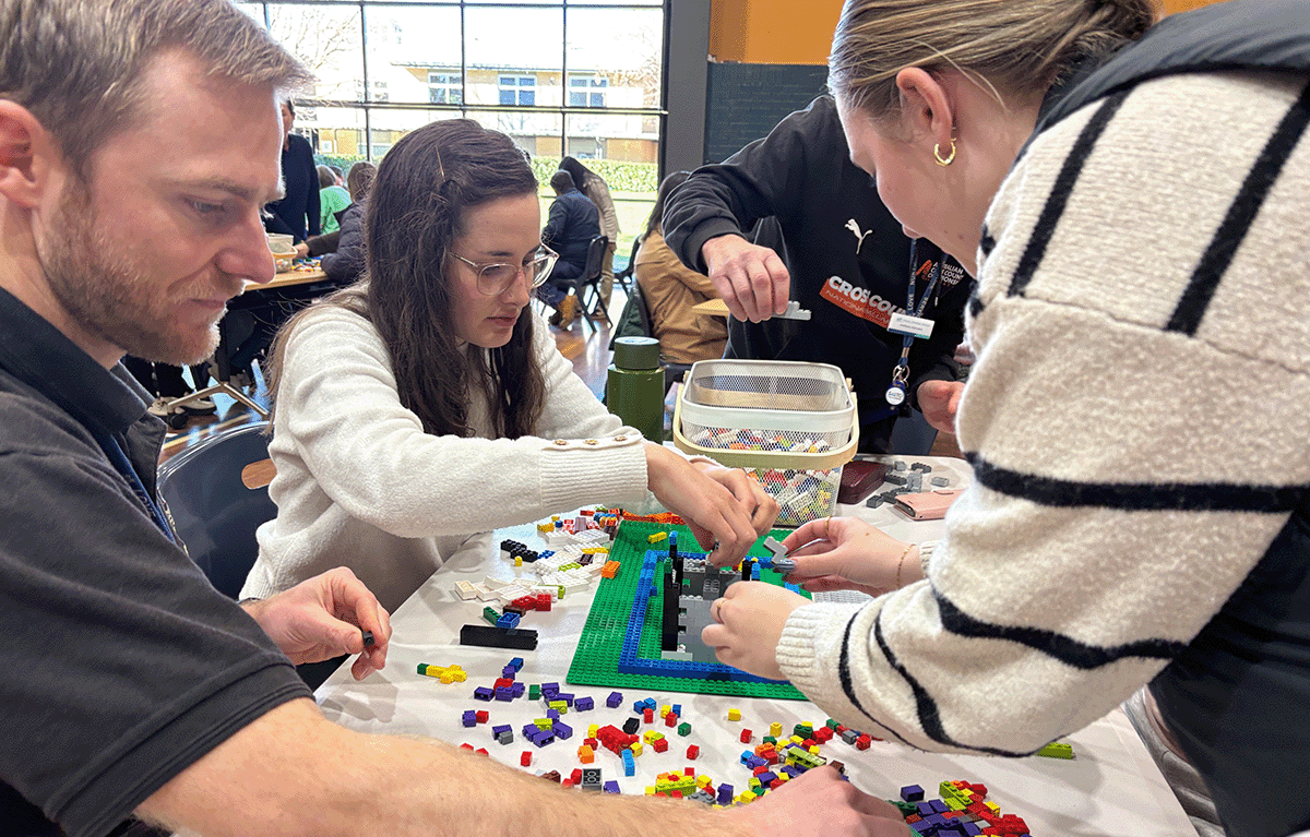 Teams building creative LEGO® masterpieces during an indoor team bonding event in Canberra.