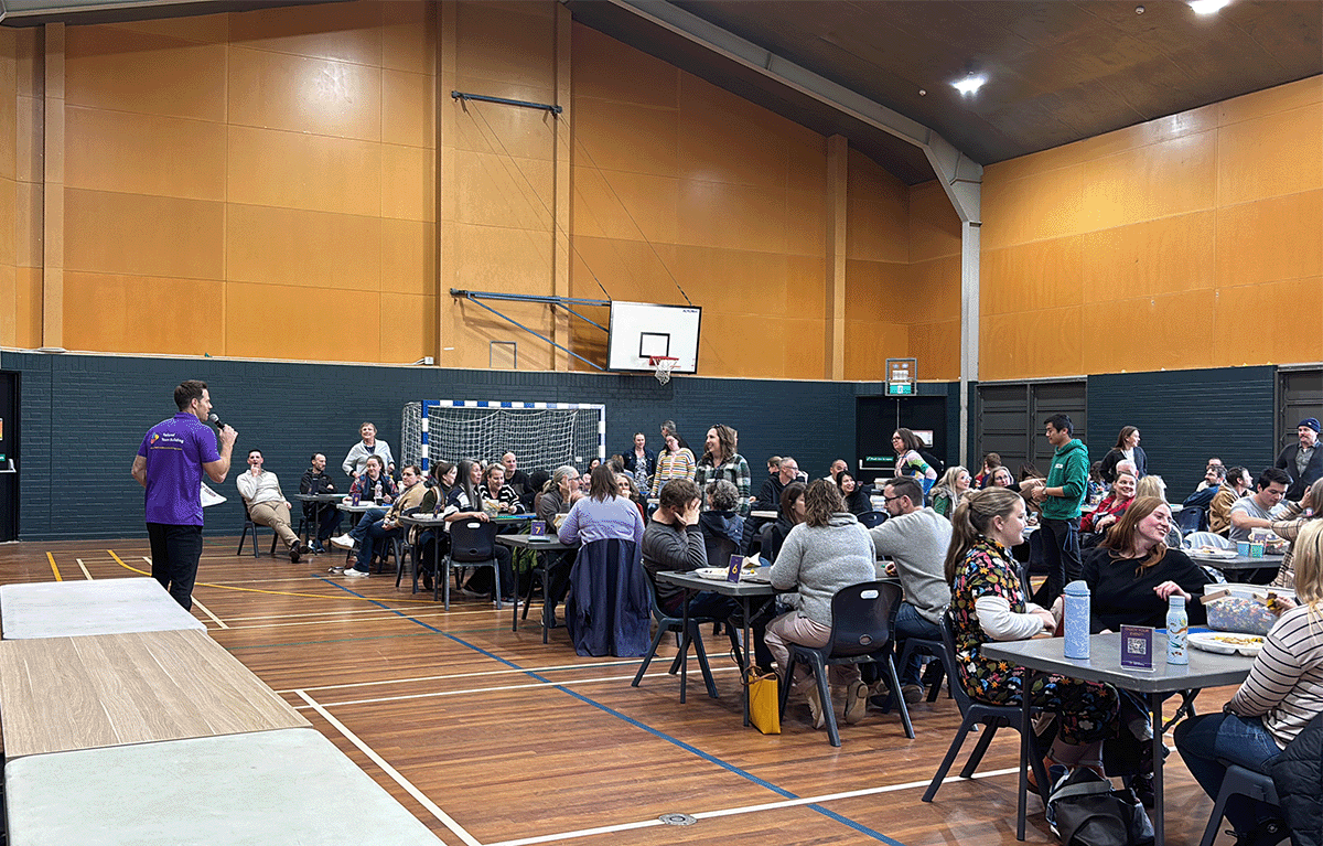 Staff competing in the tallest tower challenge at a Canberra Brick Masters team building event.