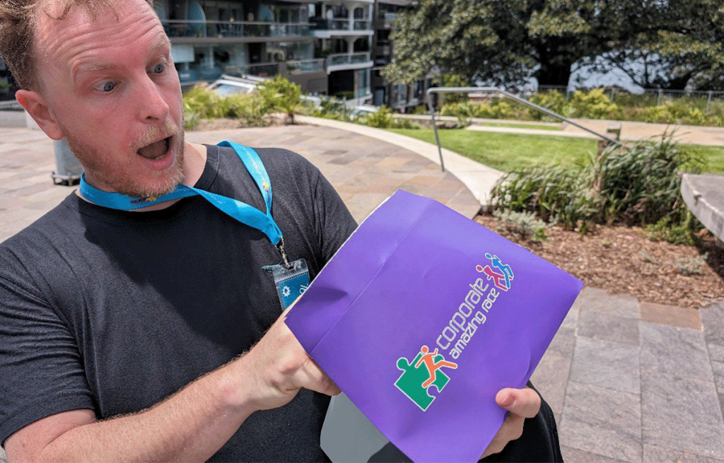 Man excited about opening a Corporate Amazing Race envelope