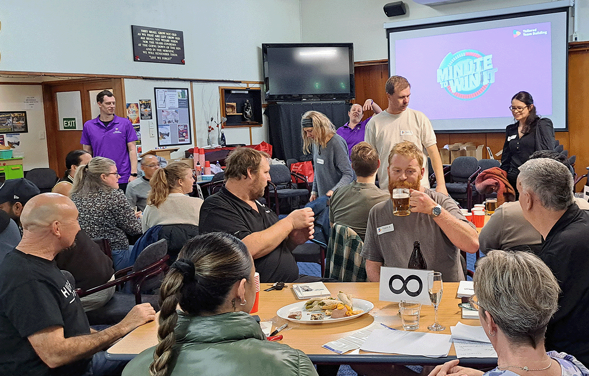 Participants celebrating during a Minute to Win It challenge at a Game Show team building event in Morrinsville.