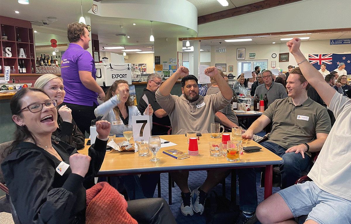 Participants celebrating during a Minute to Win It challenge at a Game Show team building event in Morrinsville.