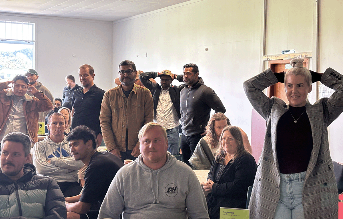 Teams laughing during an indoor team bonding event with Family Feud and The Price Is Right style games.